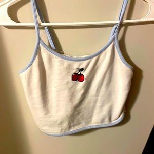 A white cropped tank top with cherry design on front